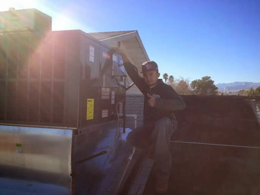 HVAC technician performing Heat Pump Repair on a rooftop unit in Meadowbrook